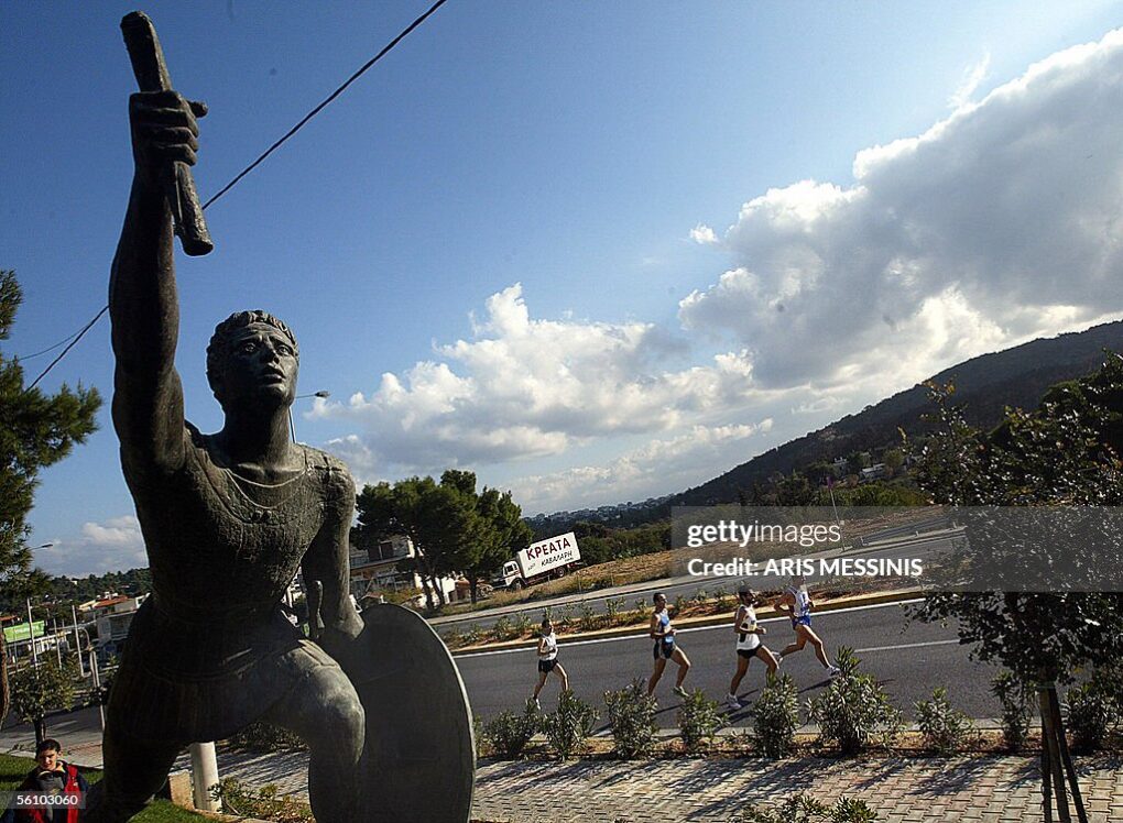 Statue of Pheidippides delivering the message before dying, and marathon runners running near it